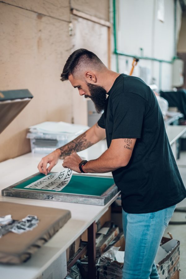 Male worker preparing screen printing film in workshop